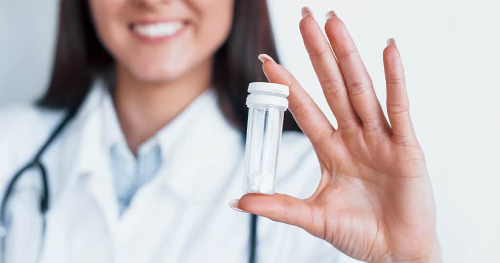 Nurse holding up a vial